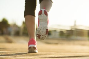 Running woman. Female runner jogging during outdoor workout on pier. Feet detail.