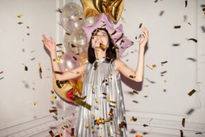woman celebrating with balloons and confetti